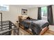 Cozy bedroom with wood frame platform bed, industrial dog crate and lots of natural light at 907 N Arlington Ave, Indianapolis, IN 46219