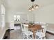 Bright dining space with a round wooden table, six chairs, and views into adjacent living area at 907 N Arlington Ave, Indianapolis, IN 46219