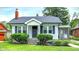 Charming home featuring manicured lawn, mature shrubbery, and a cozy front porch entrance at 907 N Arlington Ave, Indianapolis, IN 46219