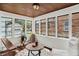 Bright sunroom with wood ceiling, multiple windows, and comfortable seating at 907 N Arlington Ave, Indianapolis, IN 46219