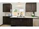 Well-lit kitchen with updated countertops, stainless steel sink, and mosaic backsplash at 9080 W Forest Dr, Elwood, IN 46036
