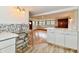 Kitchenette with stainless steel sink and mosaic backsplash, leading to the living area at 9080 W Forest Dr, Elwood, IN 46036