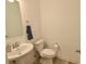A small bathroom includes a toilet, sink, mirror, and a mounted towel bar and toilet paper holder at 9640 Katana Cir, Fishers, IN 46040