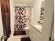 A bathroom with decorative shower curtain, tile floors, and vanity with a sink at 9640 Katana Cir, Fishers, IN 46040