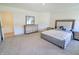 A well-lit bedroom with carpet and a bed and a large dresser with mirror at 9640 Katana Cir, Fishers, IN 46040
