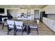 Open concept dining room with dark wooden table and upholstered chairs with views of the kitchen and living room at 9640 Katana Cir, Fishers, IN 46040