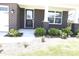Home's entryway features manicured landscaping, dark brick facade and white trim at 9640 Katana Cir, Fishers, IN 46040