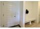 Bright entryway features a white bench with storage for shoes and hooks for hanging coats and backpacks at 9640 Katana Cir, Fishers, IN 46040