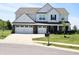 Charming two-story home featuring a three-car garage, well-manicured lawn, and inviting curb appeal at 9640 Katana Cir, Fishers, IN 46040