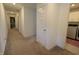 Well-lit hallway with neutral carpeting leading to various rooms, including the laundry area at 9640 Katana Cir, Fishers, IN 46040