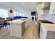 Long view of a kitchen with stainless steel appliances, white cabinets and an island at 9640 Katana Cir, Fishers, IN 46040