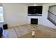 Bright living room featuring a black fireplace, mounted TV and staircase with black metal railings at 9640 Katana Cir, Fishers, IN 46040