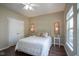 Light and airy bedroom with two windows, a white metal bed frame, and dark hardwood floors at 9743 Herons Cv, Carmel, IN 46280