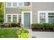 Inviting front entrance with well-maintained landscaping, complemented by a gray door and bright white trim at 9743 Herons Cv, Carmel, IN 46280