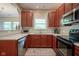 Functional kitchen with stainless steel appliances, wood cabinetry, and plenty of counter space, ready for cooking at 9743 Herons Cv, Carmel, IN 46280