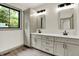 Bright bathroom with double vanity sinks, great lighting and an exterior view at 9811 Warren Pl, Indianapolis, IN 46229