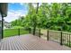 Spacious outdoor deck with black metal railings and a beautiful view of the lush green backyard and wooded area at 9811 Warren Pl, Indianapolis, IN 46229