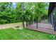 Exterior view of the wooden deck with metal railings overlooking the lush greenery of the backyard at 9811 Warren Pl, Indianapolis, IN 46229