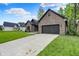 Brick home with a well-manicured lawn and a two-car garage, offering comfort and curb appeal at 9811 Warren Pl, Indianapolis, IN 46229