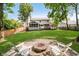 A scenic backyard with a fire pit area, surrounded by green lawns and trees, offering a tranquil outdoor space at 10243 Brixton Ln, Fishers, IN 46037