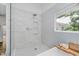 Bathroom with tiled shower and soaking tub, alongside a window for natural light and ventilation at 10243 Brixton Ln, Fishers, IN 46037
