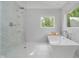 New bathroom showcasing a soaking tub and glass-enclosed shower in a bright, updated space at 10243 Brixton Ln, Fishers, IN 46037