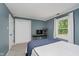 Bedroom with carpet and blue walls showcases a window with a view of mature trees outside at 10243 Brixton Ln, Fishers, IN 46037