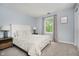 Bedroom with light blue walls, carpet, a cozy bed, and a window with views of greenery at 10243 Brixton Ln, Fishers, IN 46037