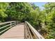 Charming wooden bridge crossing a peaceful stream, surrounded by lush trees, creating a serene natural landscape at 10243 Brixton Ln, Fishers, IN 46037