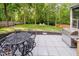 Outdoor patio features a modern table and grill, nestled within a lush backyard and a cozy firepit area at 10243 Brixton Ln, Fishers, IN 46037