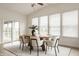 Bright dining area featuring a wood table, modern chairs, and a sliding door to the patio at 10922 Liberation Trce, Noblesville, IN 46060