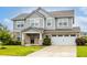 Beautiful two-story home features a gray exterior, brick accents, attached garage, and a well-maintained lawn at 10922 Liberation Trce, Noblesville, IN 46060