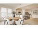 Open concept featuring a kitchen with island seating flowing into a dining area with a stylish table at 10922 Liberation Trce, Noblesville, IN 46060