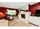 Comfortable living room with a white brick fireplace, red walls, and a cozy armchair, ideal for relaxation at 1102 Fox Hill Dr, Indianapolis, IN 46228