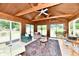 Bright sunroom features wood ceiling with exposed beams, large windows, and a ceiling fan, inviting natural light and comfort at 1102 Fox Hill Dr, Indianapolis, IN 46228