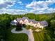 Stunning aerial view of a large luxury home with beautiful landscaping, a circular driveway, and mature trees at 11101 Hawthorn Rdg, Fishers, IN 46037