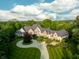 Stunning aerial view of a luxury home featuring manicured lawns, a circular driveway, and mature trees at 11101 Hawthorn Rdg, Fishers, IN 46037