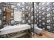 Powder room with unique wallpaper, designer sconces, marble sink and vanity, and toilet at 11101 Hawthorn Rdg, Fishers, IN 46037