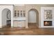 Charming bar area with custom cabinetry, an arched entry, and a view of the fireplace with unique art at 11101 Hawthorn Rdg, Fishers, IN 46037