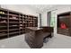 Wide shot of a custom closet with wood cabinets, shelves, center island with seating, and chandelier at 11101 Hawthorn Rdg, Fishers, IN 46037