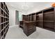 Walk-in closet featuring wood shelving, carpet floors, center island with drawer storage, and modern lighting at 11101 Hawthorn Rdg, Fishers, IN 46037