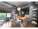 Dark painted dining room with wood floors features a modern light fixture and an adjacent seating area at 11101 Hawthorn Rdg, Fishers, IN 46037