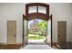 Grand entryway showcasing a beautiful wooden door with decorative glass and a view of the landscaped yard at 11101 Hawthorn Rdg, Fishers, IN 46037