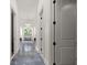 Hallway with sleek herringbone-patterned floors leading to a bathroom with chandelier and soaking tub at 11101 Hawthorn Rdg, Fishers, IN 46037