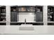 Wet bar with white stone countertops, a stainless steel sink and black cabinetry at 11101 Hawthorn Rdg, Fishers, IN 46037