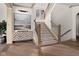 Elegant staircase with carpet runner and wooden banister, illuminated by a window, next to art covered console table at 11101 Hawthorn Rdg, Fishers, IN 46037