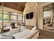 Inviting sunroom featuring hanging swing chairs, stone accent wall, and view of lush greenery at 11101 Hawthorn Rdg, Fishers, IN 46037