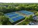 Aerial view of multiple outdoor tennis courts with manicured landscaping and clubhouse nearby at 11101 Hawthorn Rdg, Fishers, IN 46037