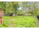 Spacious backyard featuring tall grass, a fence, and mature trees at 1113 Delray Dr, Indianapolis, IN 46241