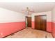 Bedroom has ceiling fan, closet, and doors with dated pink paint at 1113 Delray Dr, Indianapolis, IN 46241
